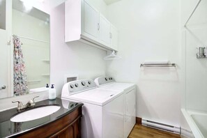 A bathroom with a sink, mirror, two dryers, and a shower. - Le Romeo Charm & Relaxation BBQ Outdoor Fire (Lévis)