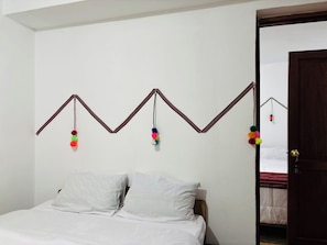 A bedroom with a bed, white walls, and a door. - Magahousecusco (Cusco)