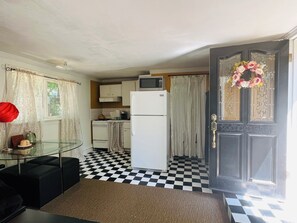 Eine kleine Küche mit Kühlschrank, Mikrowelle und Herd.