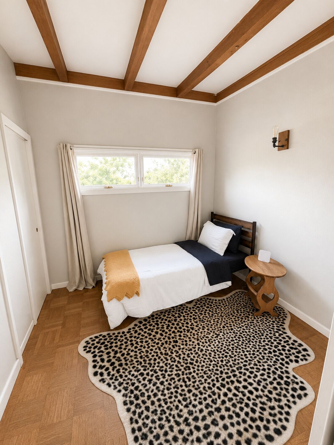 A bedroom with a bed, a window, a wooden ceiling, a small round table, and a leopard print rug.. 15 Mins to CWS - Charles Schwab Field!