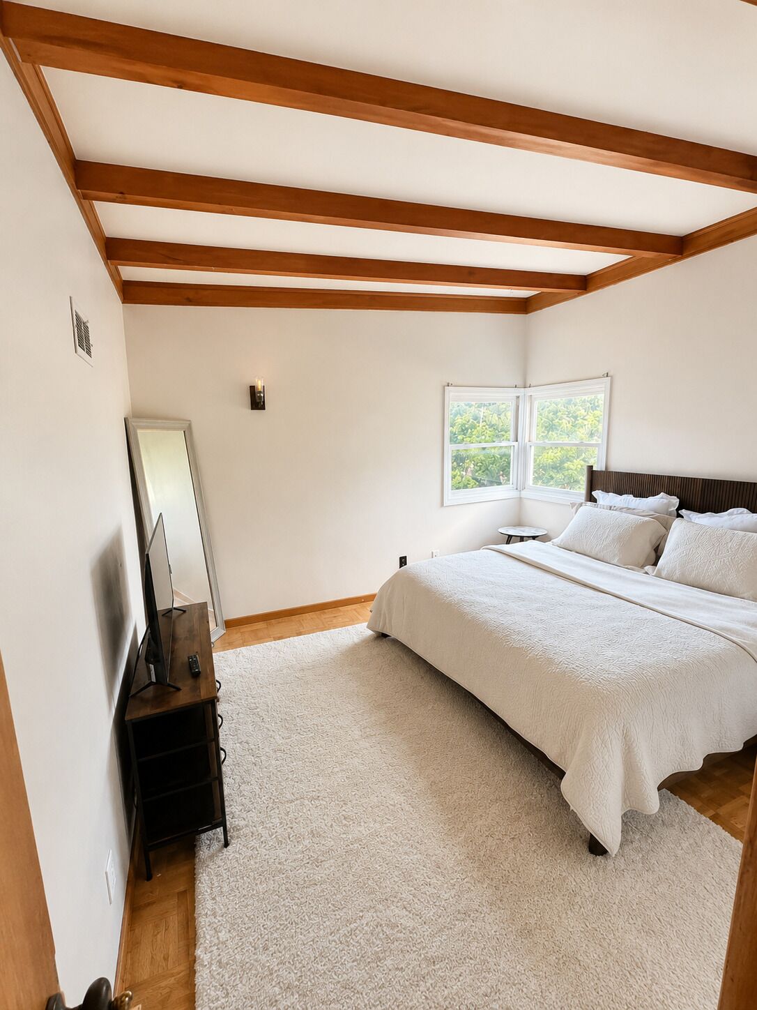 A bedroom with a bed, a TV, a window, and wooden beams on the ceiling.. 15 Mins to CWS - Charles Schwab Field!