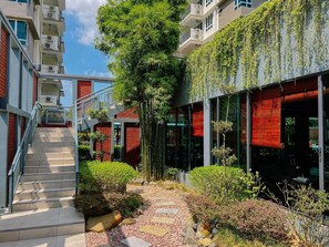 A modern building with a red brick facade, glass windows, and a staircase leading to an upper level. - Trival Lavender Homestay @ Sri Indah Sandakan (Sandakan)