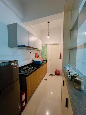 A modern kitchen with a refrigerator, stove, and cabinets. - Trival Lavender Homestay @ Sri Indah Sandakan (Sandakan)