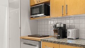 Cozinha equipada com lava-louças, micro-ondas, torradeira e máquina de café.