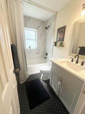 Un baño con bañera, inodoro y lavabo.