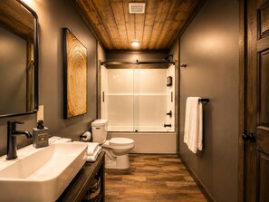 Une salle de bain avec un lavabo, des toilettes et une douche.