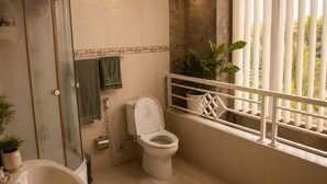 Een badkamer met douche, toilet en een raam met balkon.