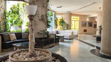 A lobby with a central water feature, seating areas, and a reception desk.