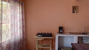 A small kitchenette with a gas stove, coffee maker, sink, and a refrigerator. - Downtown 2-story Tiny House (Granada)