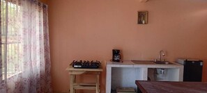 A small kitchenette with a gas stove, coffee maker, sink, and a refrigerator. - Downtown 2-story Tiny House (Granada)
