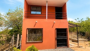 A two-story building with a flat roof, a balcony, and a covered area. - Downtown 2-story Tiny House (Granada)