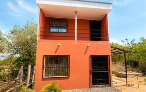 A two-story building with a flat roof, a balcony, and a covered area. - Downtown 2-story Tiny House (Granada)