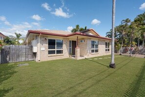 A single-story house with a red roof, a fenced backyard, and a palm tree. - Sweet Retreat Rosslea (Rosslea)