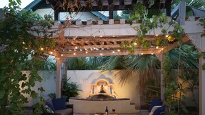 An outdoor patio with a pergola, seating, a fountain, and a wall with a decorative design. - Downtown Phoenix Studio – Walk to Arts & Dining (Phoenix)