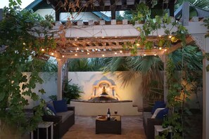 An outdoor patio with a pergola, seating, a fountain, and a wall with a decorative design. - Downtown Phoenix Studio – Walk to Arts & Dining (Phoenix)