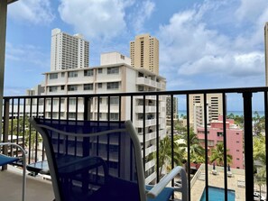 Ein Balkon mit Blick auf hohe Gebäude und einen Poolbereich.