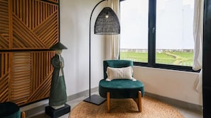 Ein Zimmer mit einem grünen Sessel, einer Stehlampe und einer dekorativen Wandverkleidung.