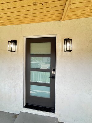 A modern door with a frosted glass panel, a small window, and two wall-mounted lights. - 洛杉矶pomona全新装  修独立屋｜2房2卫三床（含高低床）｜室内洗烘｜免费停车｜最多4人｜精致原木风 (Pomona)