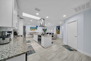 A modern kitchen with granite countertops, stainless steel appliances, and a central island.