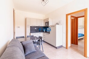 Un apartamento moderno con kitchenette, comedor y habitación.