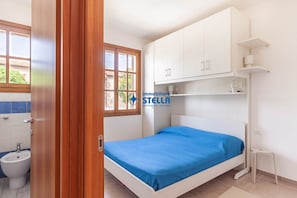 A bedroom with a bed, a window, a white wardrobe, and a small bedside table. - # residence Francesca°# swimming pool* (Jesolo)