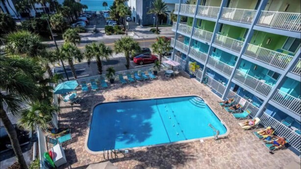 A hotel with a pool, palm trees, and a view of the ocean. - COSTAL GETAWAY ON CLEARWATER BEACH (Clearwater)