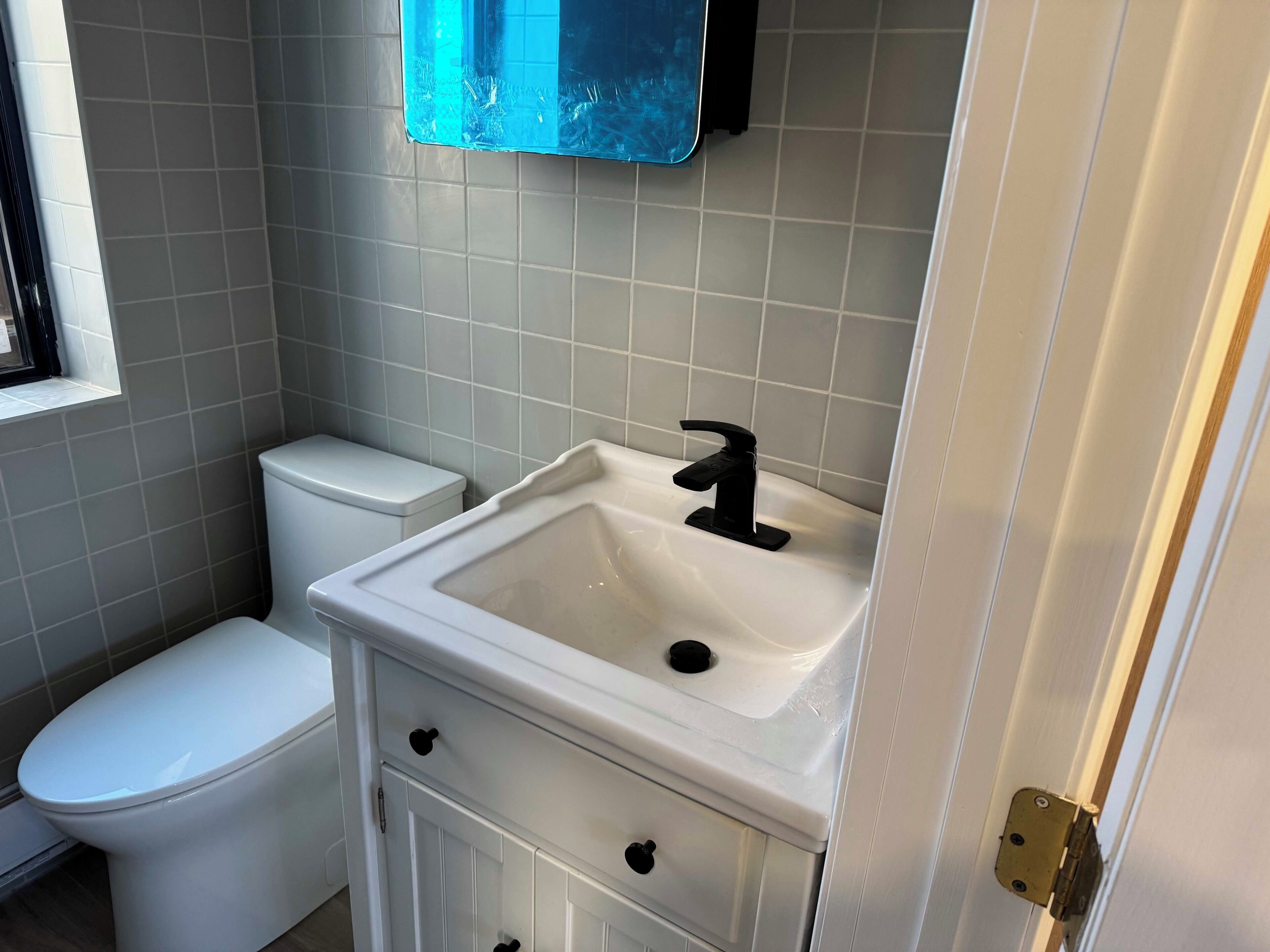 Une salle de bain avec des toilettes, un lavabo et un miroir.
