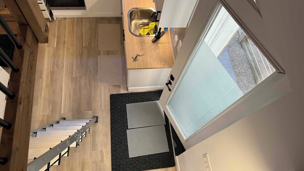 Cocina compacta con microondas, pileta y ventana.