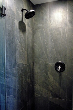 Ein Duschbereich mit Handbrause und Armaturen an der Wand.