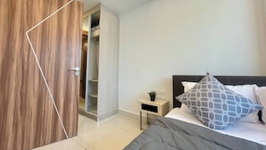 A bedroom with a bed, bedside table, and a wardrobe. - Room-stylish 1BR Garden View at Laguna B (Pattaya)