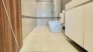 A modern bathroom with a toilet, shower, and vanity. - Room-stylish 1BR Garden View at Laguna B (Pattaya)