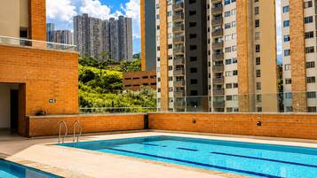 A swimming pool with a view of high-rise buildings and greenery.