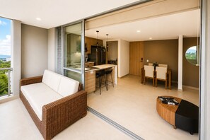 Uma sala de estar moderna com um sofá, uma área de jantar e uma cozinha.