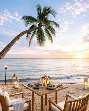A beachside dining setup with a table, chairs, and a palm tree. - Cosi Beach Hotel Phu Quoc - Sunset (Phu Quoc)