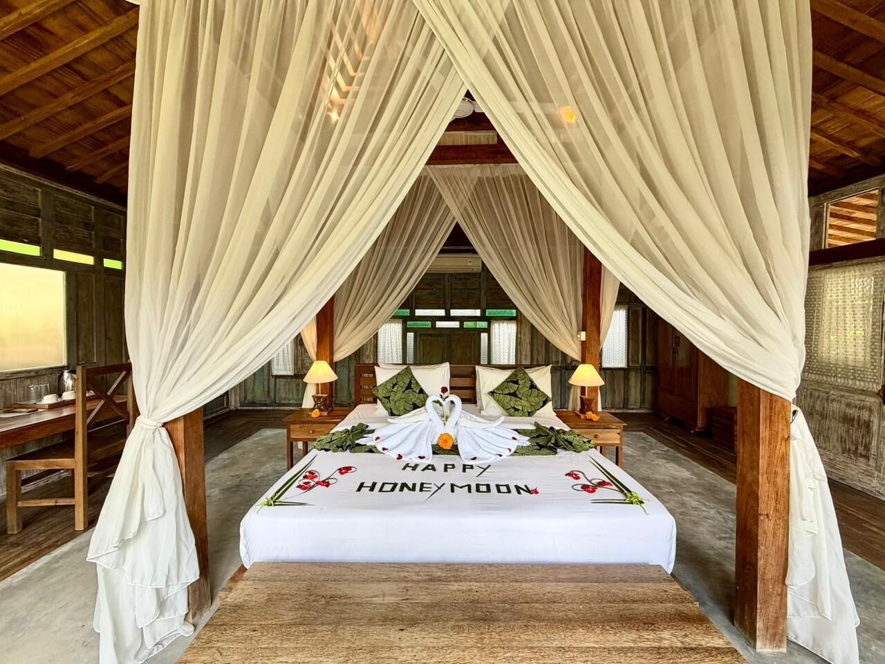 A honeymoon suite with a canopy bed, a 'Happy Honeymoon' message, and a wooden interior.