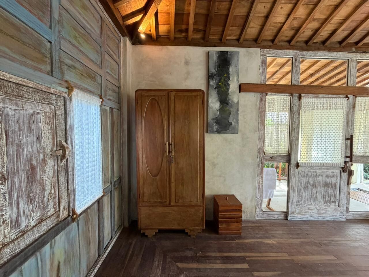 A rustic room with wooden cabinets, a large cabinet, and a small wooden chest.