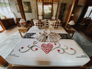 A bed with a heart design, two pillows, and a towel arrangement. - Sarini Villas by Manara (Gianyar)