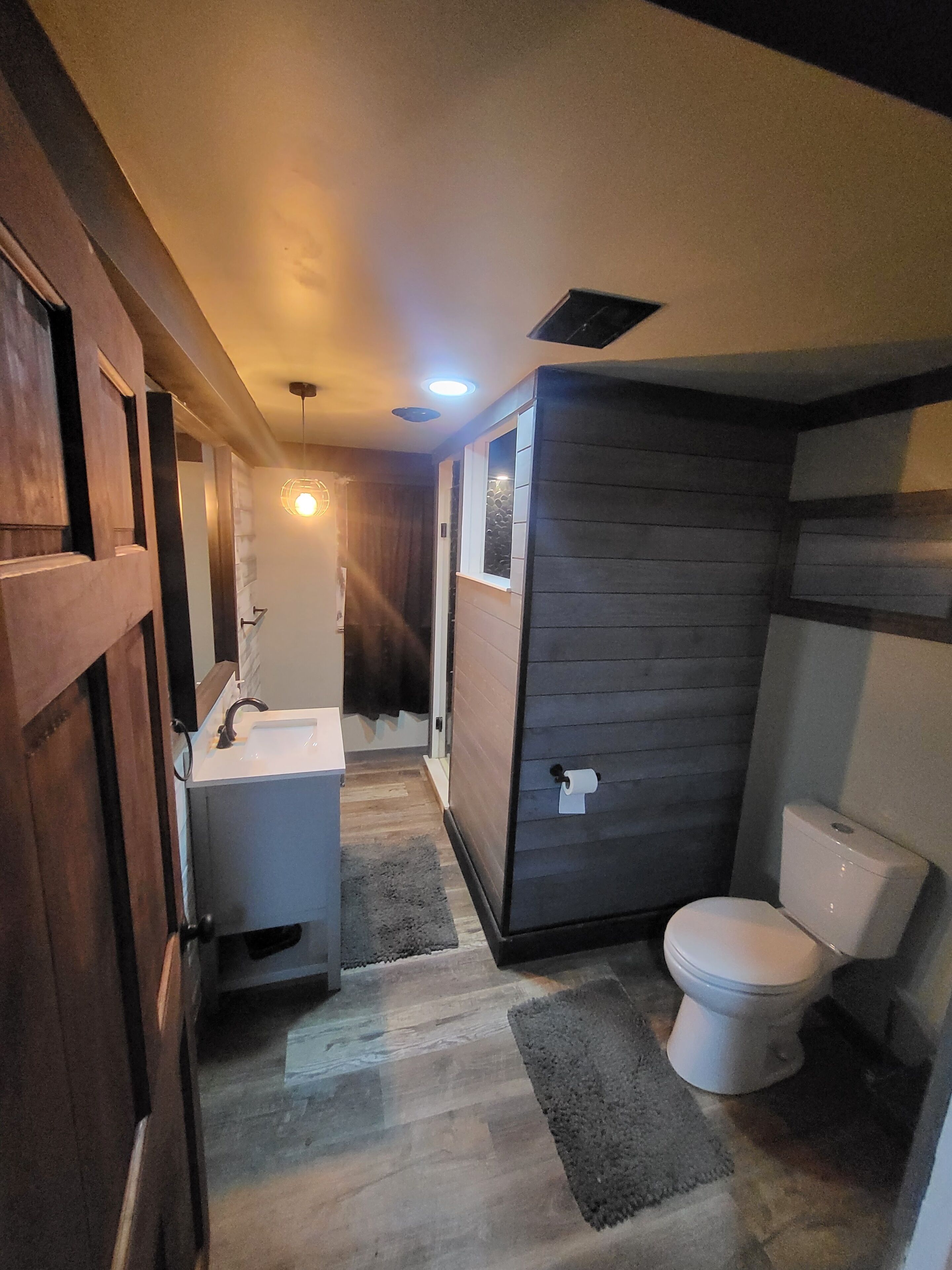 Une petite salle de bain comprenant des toilettes, un lavabo et un espace douche.
