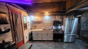 A compact kitchen with a built-in oven, a refrigerator, and a microwave.
