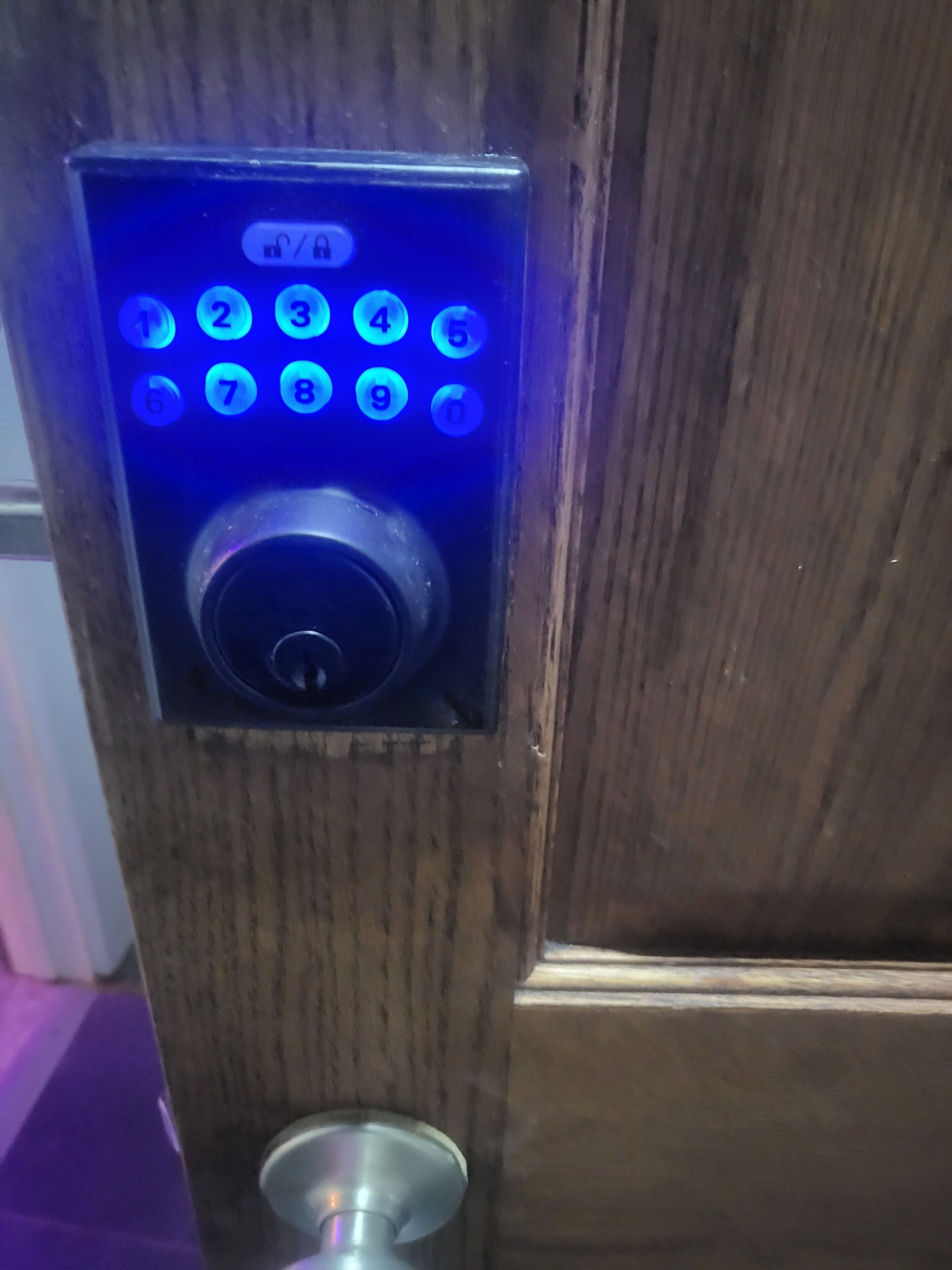 A door with a keypad lock and a keyhole.