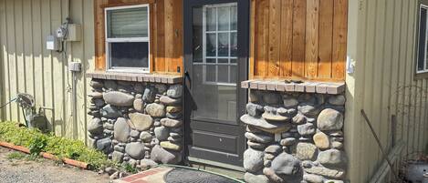 A single-story building with a stone foundation, a wooden front door, and a small window.