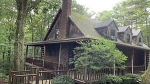 A wooden cabin with a porch and a chimney, surrounded by trees. - Walk to Cushing Academy ! Sleeps 10 (Ashburnham)
