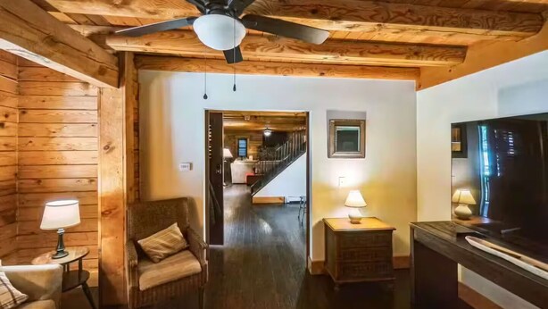 A wooden interior with a sofa, a television, and a lamp. - Walk to Cushing Academy ! Sleeps 10 (Ashburnham)