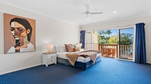 A bedroom with a bed, nightstand, and a painting on the wall.