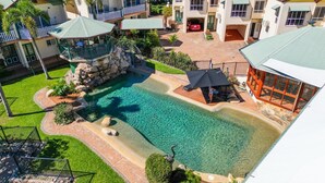 Un hotel con piscina, posti a sedere all'aperto e una zona coperta.