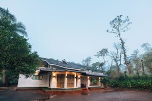 A traditional house with a porch, large windows, and a brick foundation. - Bastians Veedu by Raho, Hidden Jungle Villa (Badagabanangala)