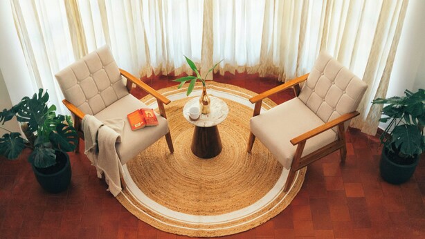Una habitación con dos sillones, una mesa de centro y una planta en maceta.