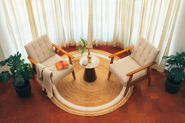A room with two armchairs, a coffee table, and a potted plant.