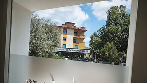 Un edificio con un letrero que dice 'I.R.C.C.S. NEUROMED' y una ventana con una vista parcial de un letrero que indica 'BED & BREAKFAST'.