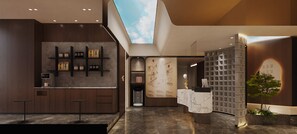 Een moderne hotel lobby met een receptiebalie, een koffieapparaat, een kaart aan de muur en een plant.